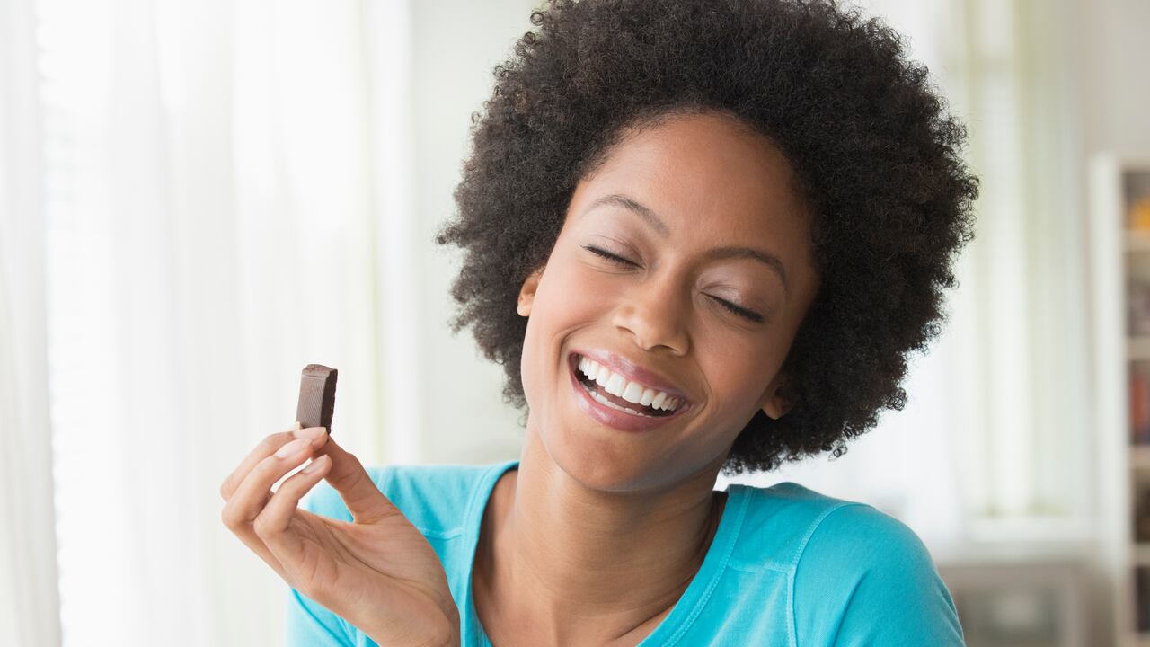 Mujer feliz comiendo chocolate