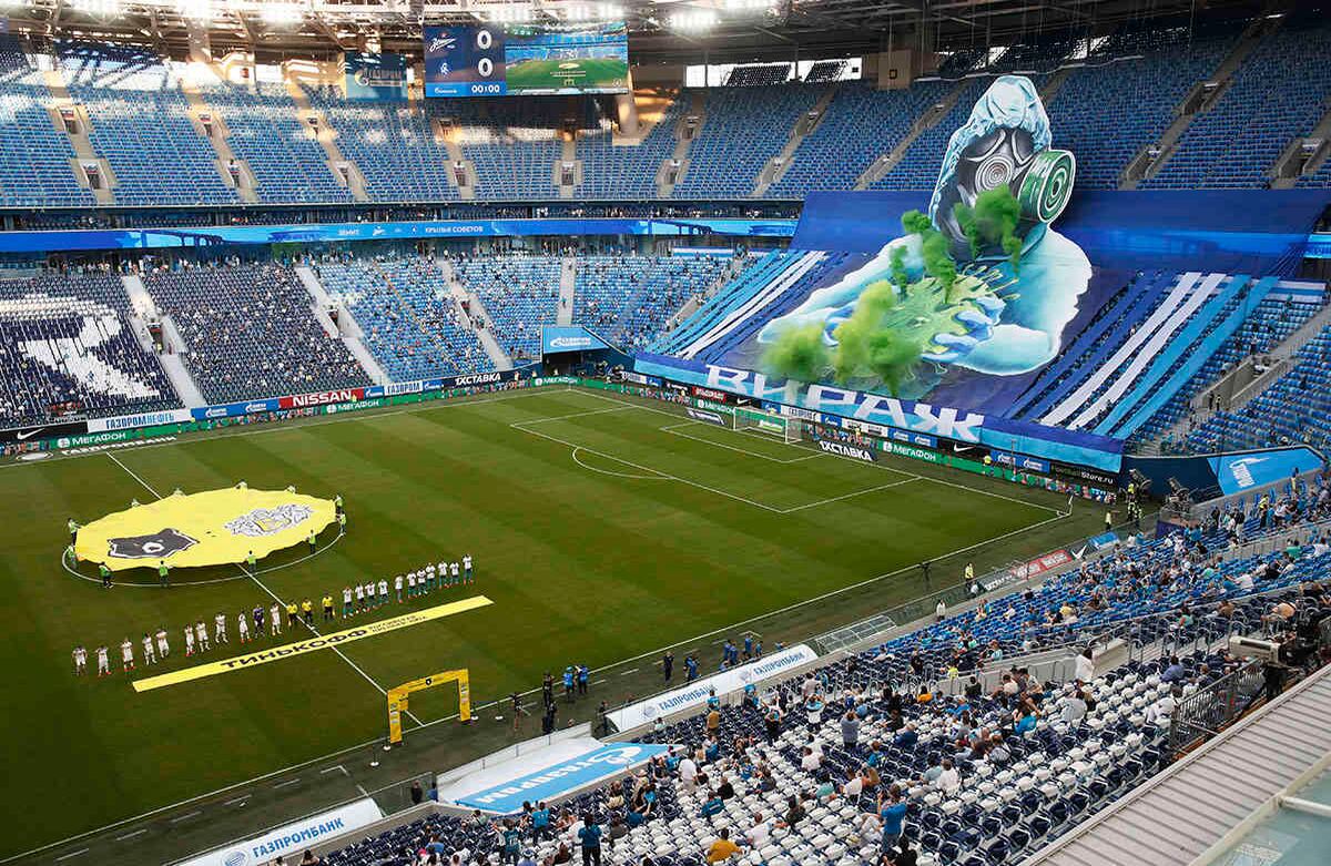 Fanáticos del Zenit extienden un póster gigante de un hombre con traje de protección y con un covid-19, antes del partido de fútbol de la Premier League rusa entre FC Zenit y Krylia Sovetov Samara en el estadio Gazprom Arena en San Petersburgo, el 26 de junio. Este fue el primer partido en el estadio después de la parálisis por la pandemia. Al encuentro asistió un número reducido de espectadores para evitar la propagación del virus. Foto: Dmitri Lovetsky / AP