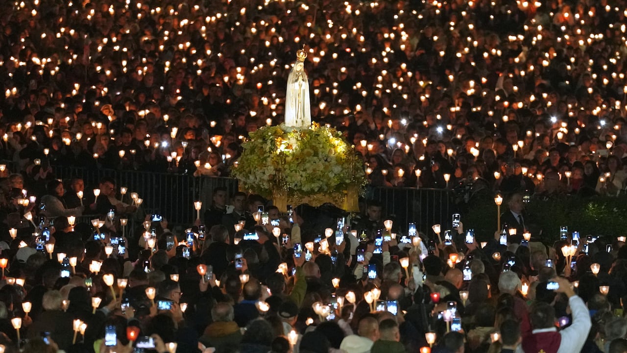 Los fieles sostienen velas y teléfonos celulares mientras la estatua de Nuestra Señora de Fátima es llevada entre la multitud durante la Procesión de las Velas, el punto culminante de las celebraciones en el santuario católico de Fátima, Portugal, el martes 13 de mayo de 2026. (Foto AP/Armando Franca)