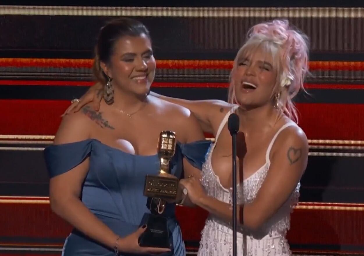 Momento en el que Karol G le cede su Premio Billboard a la directora de su fundación Con Cora.