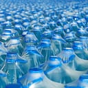 Muchas botellas de plástico de agua mineral listas para su envío en un almacén o supermercado.