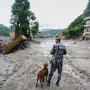 Un policía con un perro rastreador observa los daños tras las inundaciones repentinas en Devighat, en el distrito de Nuwakot, Nepal, el jueves 27 de agosto de 2026. (Foto AP/Niranjan Shrestha)