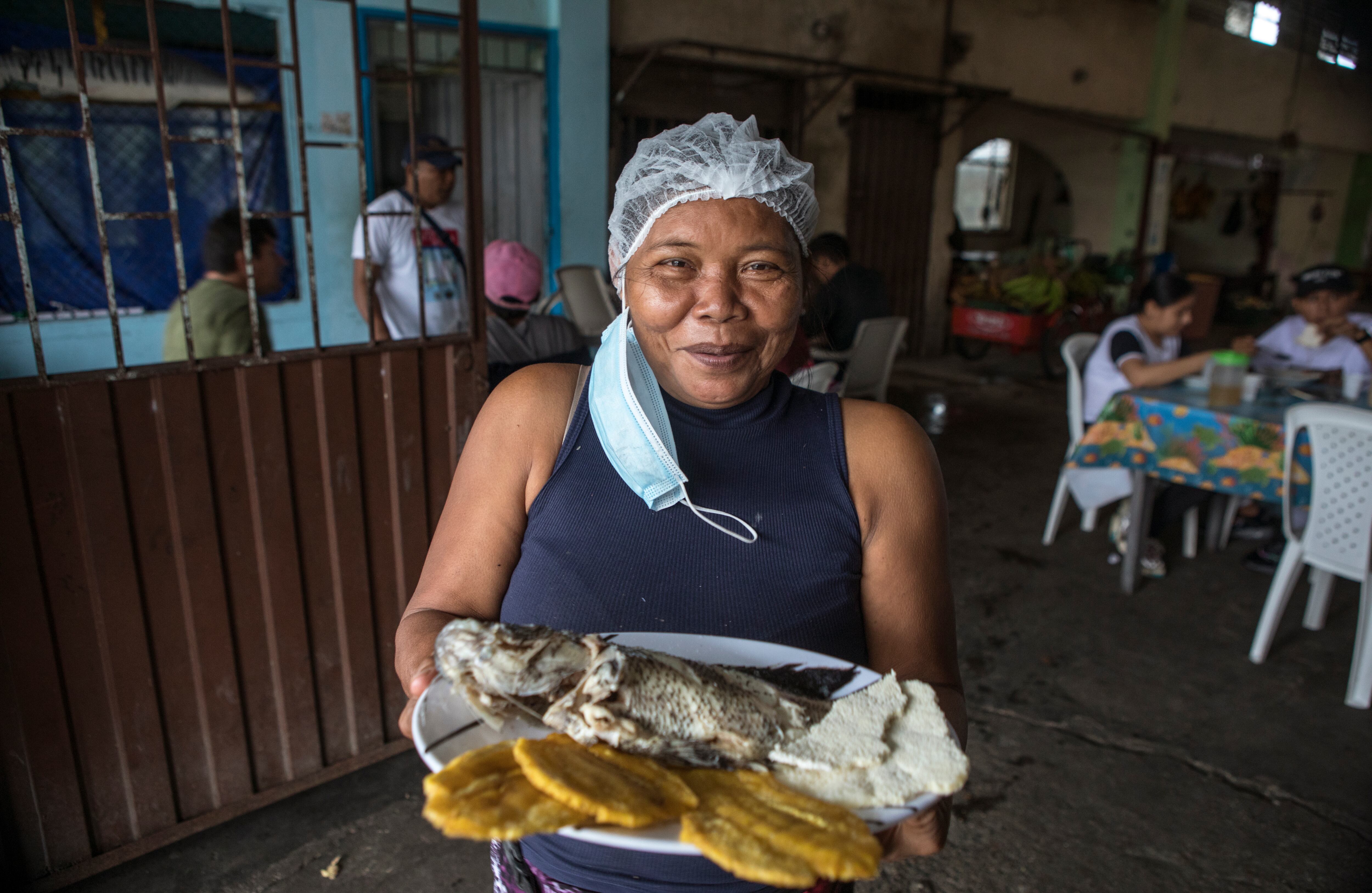 En una esquina de la plaza de mercado central de Inírida, Ligia Pacheco y sus hijos atienden un pequeño puesto dedicado a la venta de ajicero; un plato típico del Guainía de pescado, casabe y, por supuesto, ají. “Inicié hace 17 años con 20 mil pesos en un puesto que tenía una mesa y un plástico en la calle”, recuerda Pacheco, quien siempre además de ajicero ofrece a sus comensales pescado guisado o frito, acompañado de patacones, mañoco y casabe. Fotos: Juan Carlos Sierra