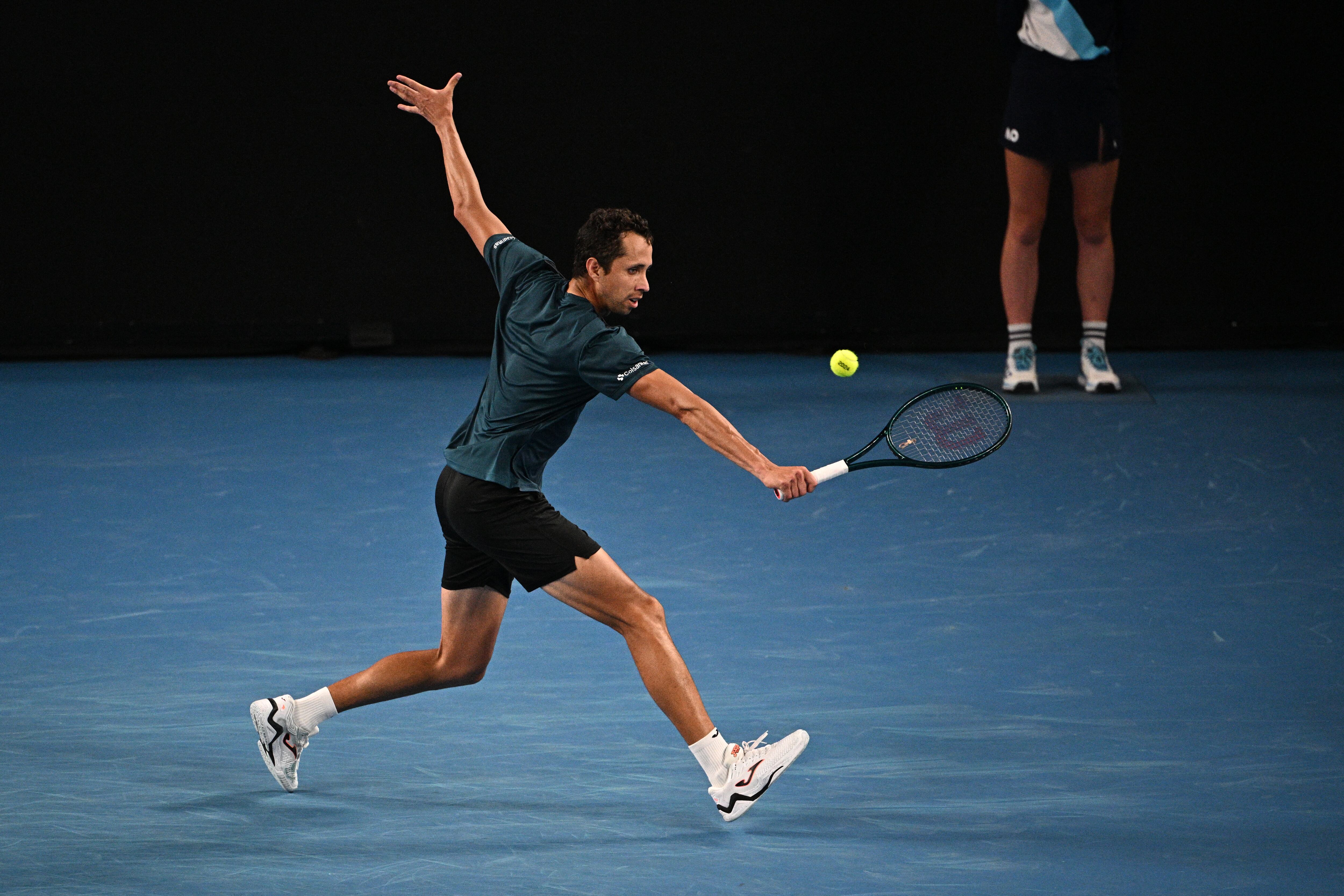 Colombia's Daniel Galan hits a return against Australia's Jason Kubler during their men's singles match on day one of the Australian Open tennis tournament in Melbourne on January 14, 2024. (Photo by Anthony WALLACE / AFP) / -- IMAGE RESTRICTED TO EDITORIAL USE - STRICTLY NO COMMERCIAL USE --