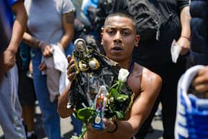 CIUDAD DE MÉXICO, MÉXICO - 2024/05/01: Un devoto sostiene una figura de la Niña Blanca (Niña Blanca), mejor conocida como 'La Santa Muerte' para bendecirla al llegar al altar de la Santa Muerte ubicado en la calle Alfarería en Tepito barrio, para agradecer los favores recibidos. (Foto de Ian Robles/Eyepix Group/LightRocket vía Getty Images)