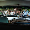Las personas que esperan en una parada de transporte público señalan un taxi colectivo en La Habana, Cuba, el martes 4 de abril de 2023.