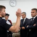 El presidente francés, Emmanuel Macron, (der.), visita la comisaría de policía de la villa olímpica, en donde le explican cómo será el trabajo. (AP Photo/Michel Euler, Pool)