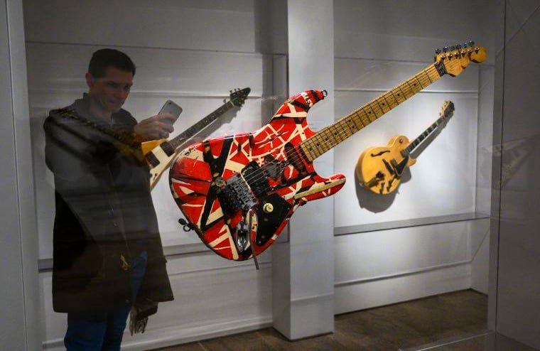 Un reportero toma una foto de "Frankenstein", la guitarra usada por Eddie Van Halen, guitarrista y fundador de la banda Van Halen. FOTO: Don Emmert / AFP