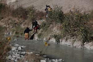 Los migrantes cruzan el Río Bravo para seguir su camino de Ciudad Juárez, México, a El Paso, Texas.