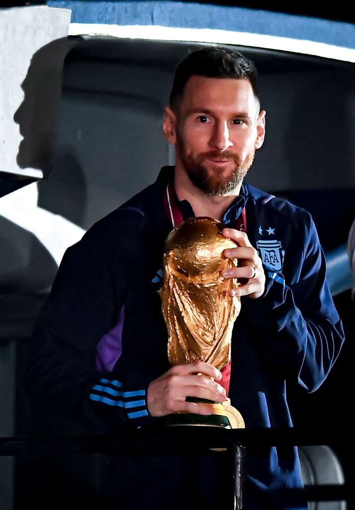 BUENOS AIRES, ARGENTINA - DECEMBER 20:  Lionel Messi holds the FIFA World Cup during the arrival of the Argentina men's national football team after winning the FIFA World Cup Qatar 2022 on December 20, 2022 in Buenos Aires, Argentina. (Photo by Marcelo Endelli/Getty Images)