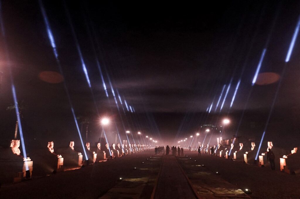 La ceremonia oficial de inauguración de la "Rams Road"  en la entrada del Templo de Luxor (construido alrededor del 1400 a. C.) en la ciudad del mismo nombre en el sur de Egipto, el 25 de noviembre. 2021. El obelisco gemelo del templo de Luxor se encuentra actualmente en la Place de la Concorde de París. - Egipto inauguró el 25 de noviembre en una grandiosa ceremonia nocturna el "Camino de los Rams" (Tareeq al-Kebbash en árabe), un camino pavimentado de arenisca de 2700 metros de largo bordeado de estatuas con cabezas de carnero y esfinges que datan de más de 3000 años, conectando el Templo de Luxor con el Templo de Karnak. Llamado "El Camino de Dios" en la mitología del Antiguo Egipto, sus estatuas de carnero, una encarnación de la antigua deidad egipcia Amón, fueron enterradas durante siglos bajo la arena antes de ser revividas y restauradas para su exhibición en los últimos años. (Foto de Khaled DESOUKI / AFP)