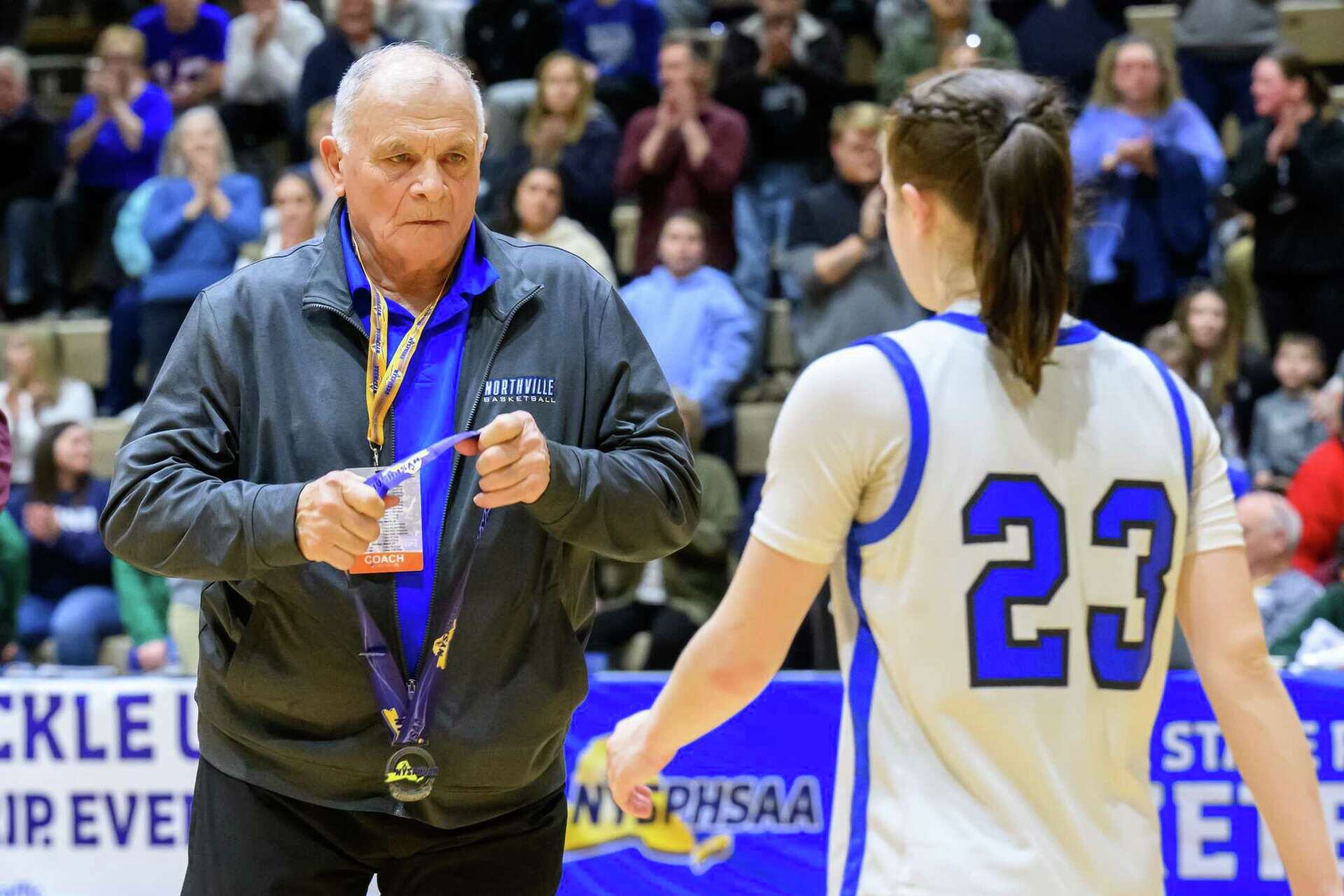 Former Northville coach Jim Zullo puts a second-place medal on standout senior Hailey Monroe after the team lost to LaFargeville in the state Class D finals on Friday, March 21, 2025 at Hudson Valley Community College in Troy, NY. Zullo was fired shortly after the contest after he was caught on film pulling Monroe’s ponytail.