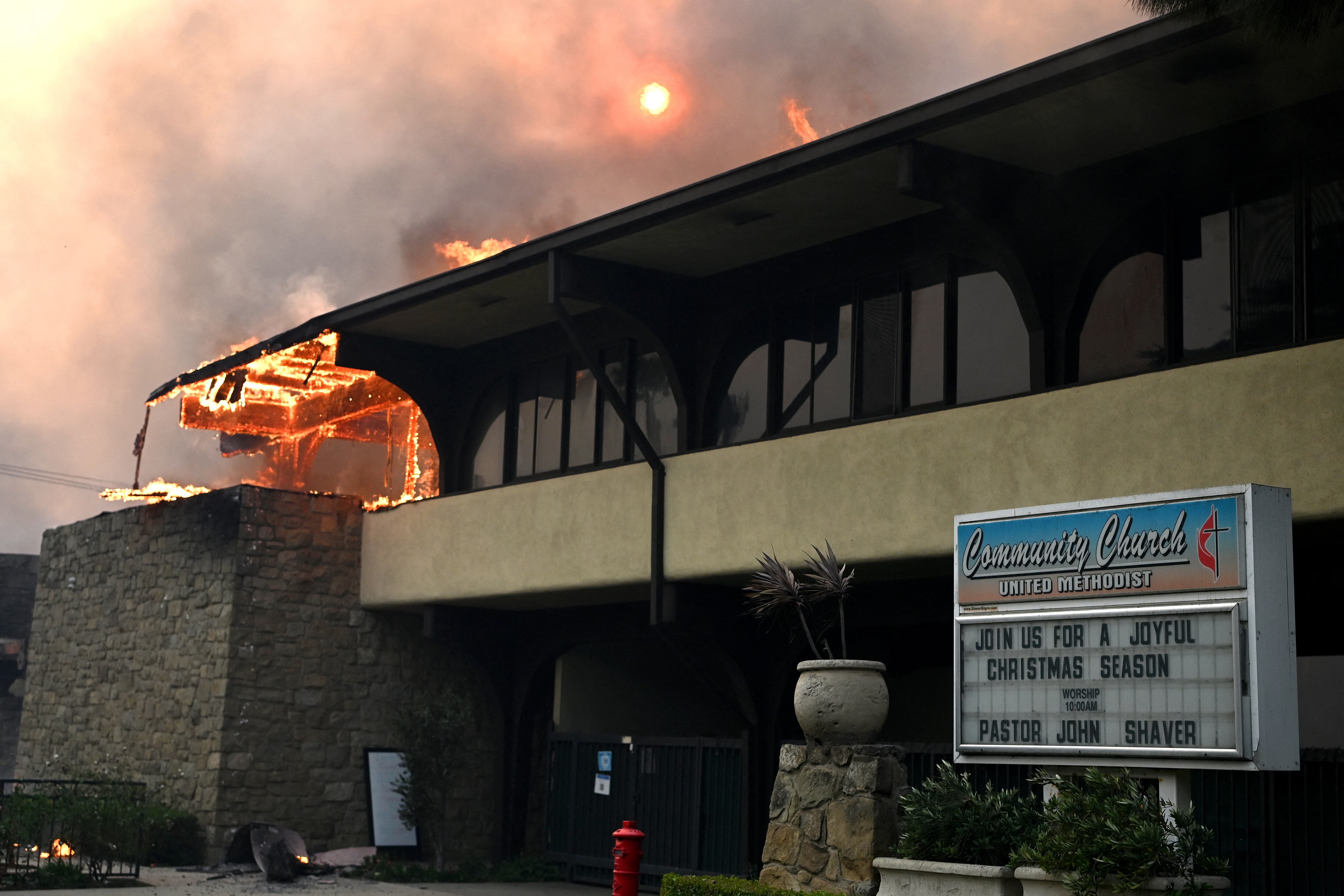 The United Methodist Community Church burns during the Palisades Fire in Pacific Palisades, California, on January 8, 2025. At least five people have been killed in wildfires rampaging around Los Angeles, officials said on January 8, with firefighters overwhelmed by the speed and ferocity of multiple blazes. (Photo by AGUSTIN PAULLIER / AFP)