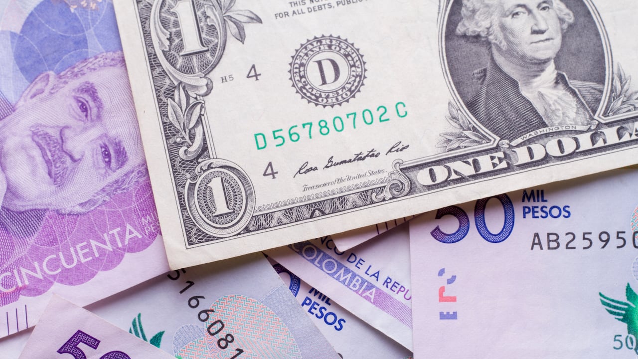 Billete de un dólar sobre pesos colombianos.