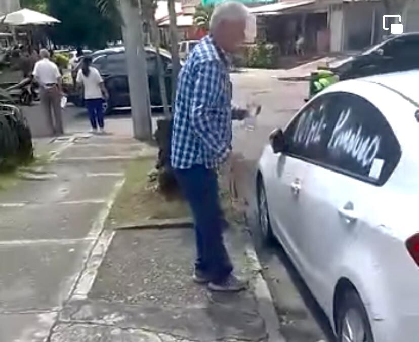 El adulto mayor fue grabado pintando el carro con aerosol.