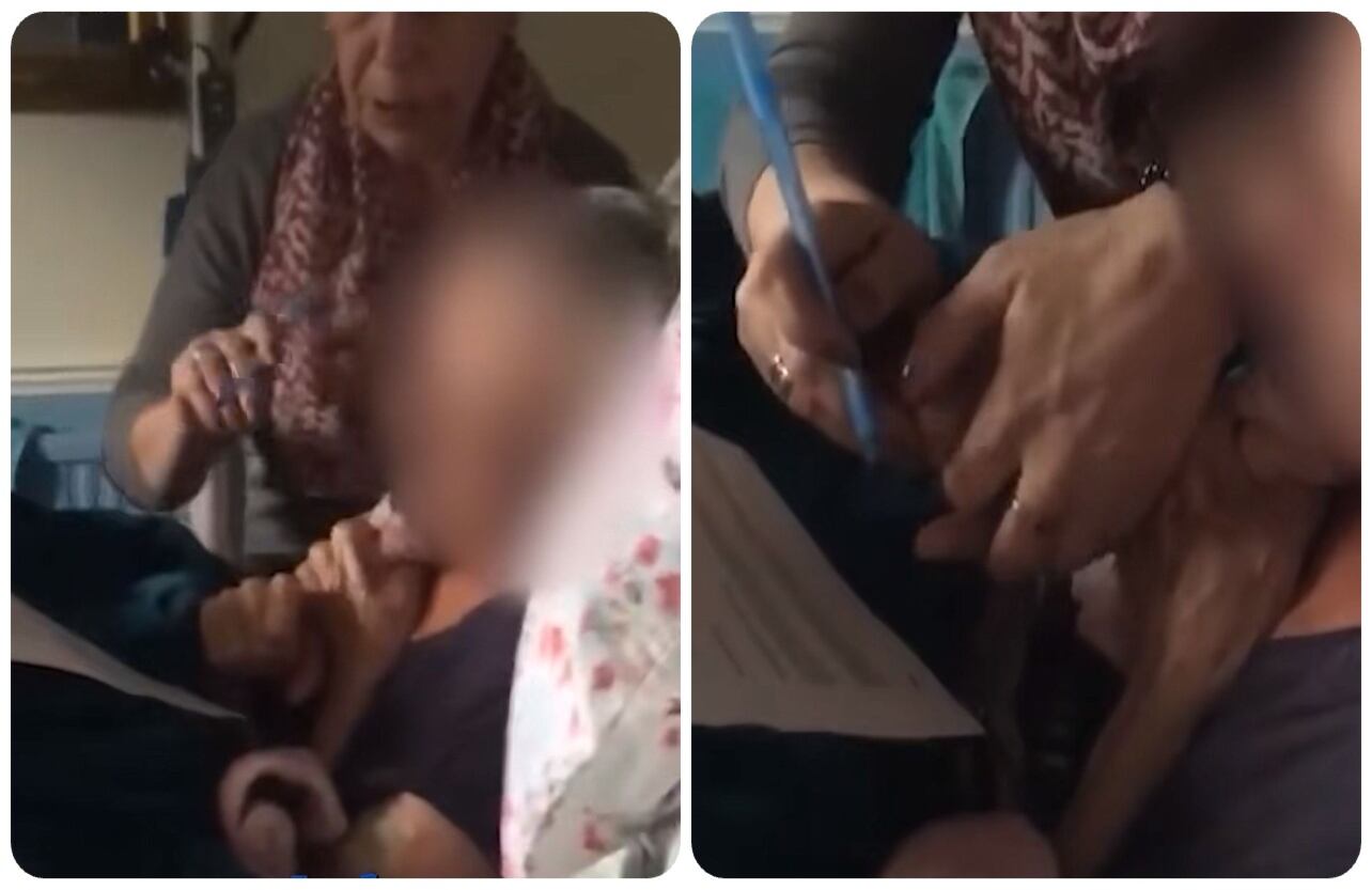 La mujer pone un bolígrafo en la mano de su madre para firmar el documento