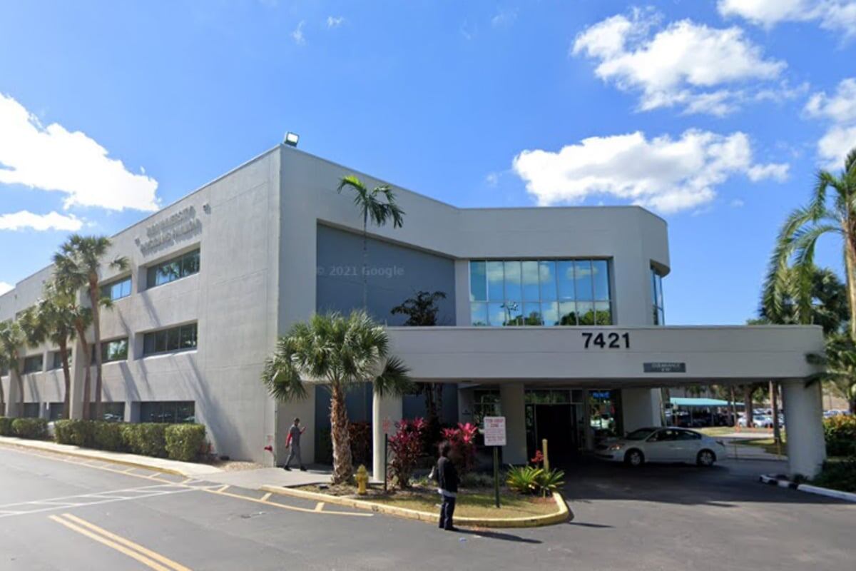 Exterior del centro médico con cinta de seguridad, patrullas y restos visibles del incendio tras la evacuación.