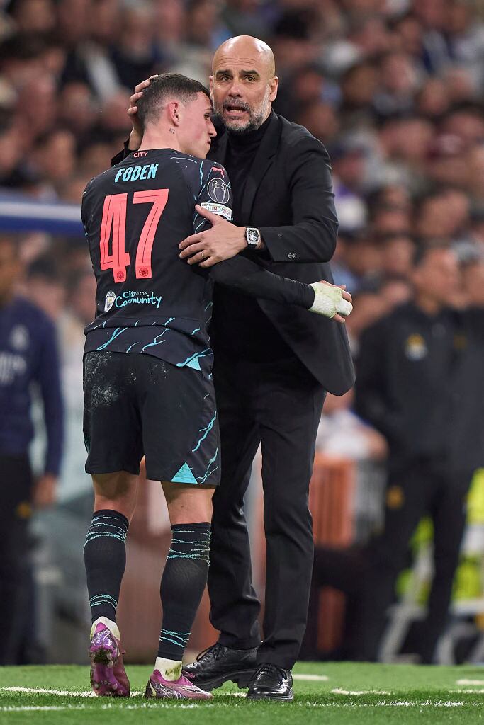 MADRID, SPAIN - APRIL 09:  Pep Guardiola, Head Coach of Manchester City hugs Phil Foden of Manchester City during the UEFA Champions League quarter-final first leg match between Real Madrid CF and Manchester City at Estadio Santiago Bernabeu on April 09, 2024 in Madrid, Spain. (Photo by Jose Manuel Alvarez/Quality Sport Images/Getty Images)