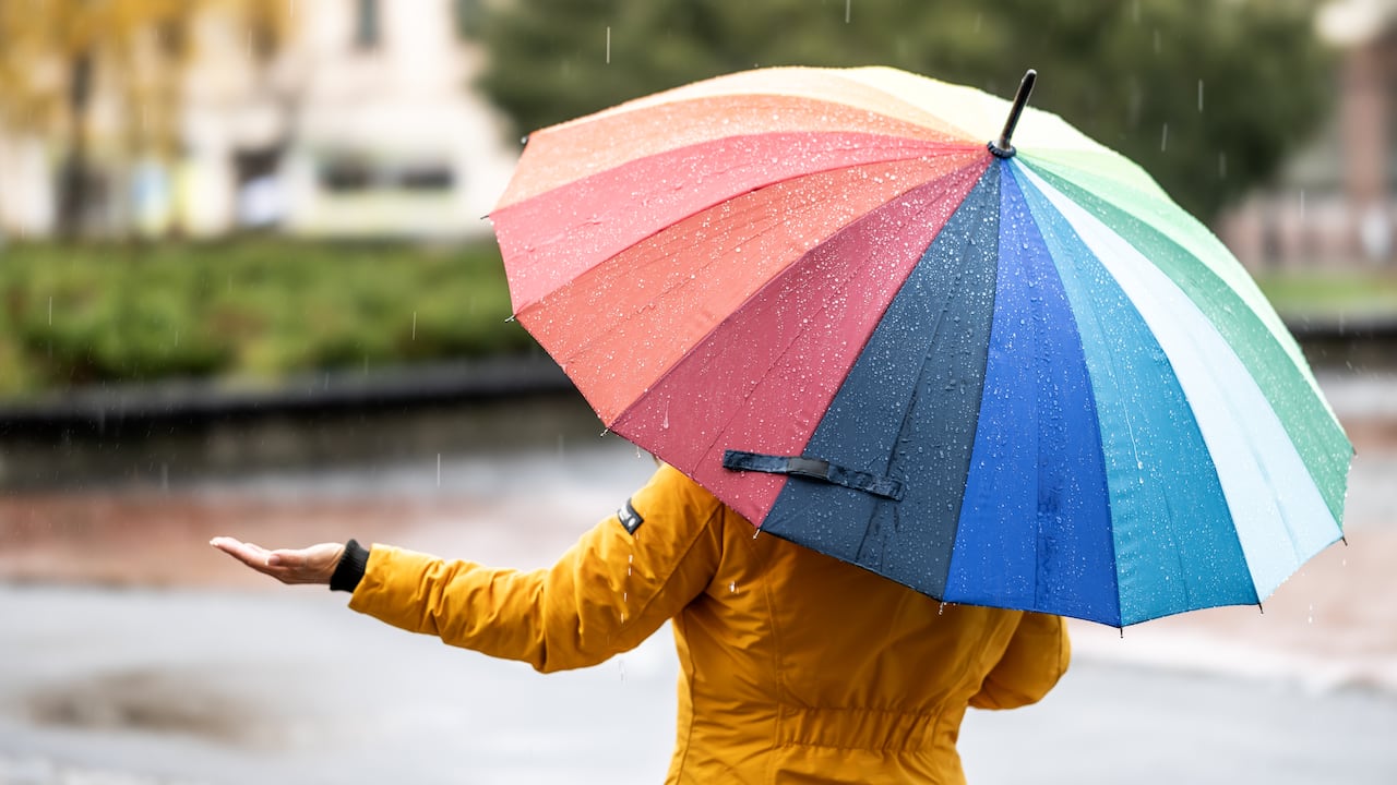 Persona resgurdándose de la lluvia.
