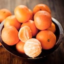 Cítricos: Clementinas en un cuenco de madera rústica.