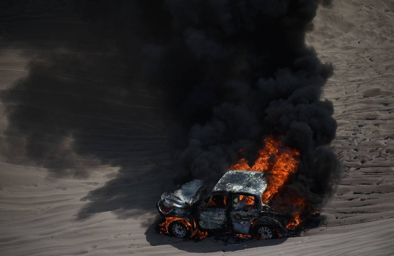 El automóvil conducido por la piloto argentina Alicia Reina y su copiloto Carlos Pelayo se incendia durante la Etapa 3 del Dakar 2018 entre Pisco y San Juan de Marcona, Perú, el 8 de enero de 2018. Los conductores escaparon ilesos. / AFP PHOTO / FRANCK FIFE.