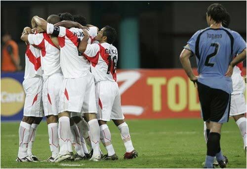 El uruguayo Diego Lugano, (derecha), observa cómo sus contrincantes peruanos celebran la primera anotación en la Copa América