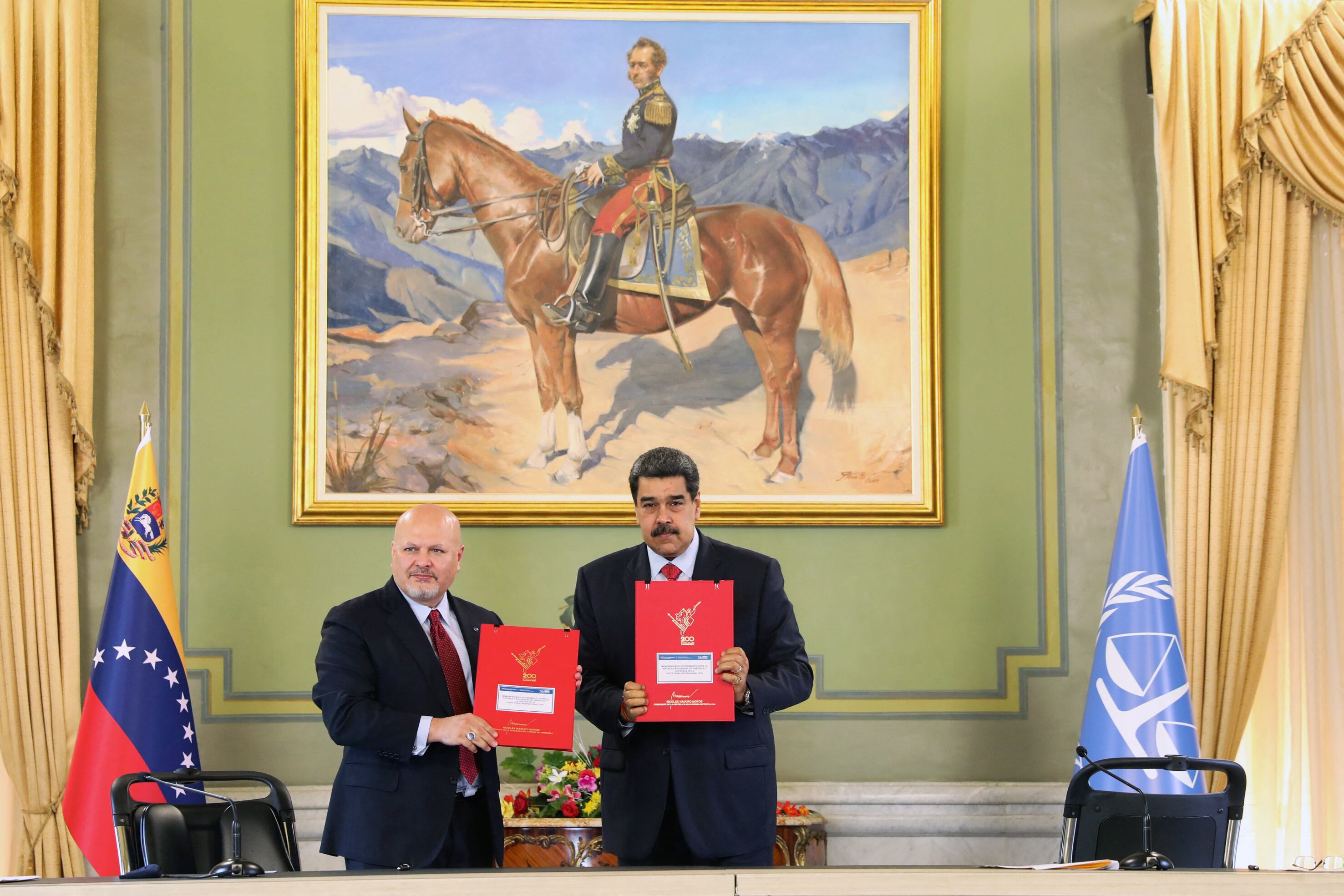 Foto del folleto publicado por la oficina de prensa del palacio presidencial de Miraflores que muestra al presidente de Venezuela, Nicolás Maduro (derecha) mientras muestra documentos con el Fiscal de la Corte Penal Internacional (CPI), Karim Khan, (izquierda) en el palacio presidencial de Miraflores en Caracas el 3 de noviembre. 2021. - Khan llegó el domingo a Venezuela como parte de una gira de 10 días por América Latina. (Foto Presidencia Venezolana / AFP) / RESTRINGIDO A USO EDITORIAL - CRÉDITO OBLIGATORIO - FOTO AFP / PRESIDENCIA VENEZOLANA - SIN MAFRKETING - SIN CAMPAÑAS PUBLICITARIAS - DISTRIBUIDO COMO SERVICIO A CLIENTES