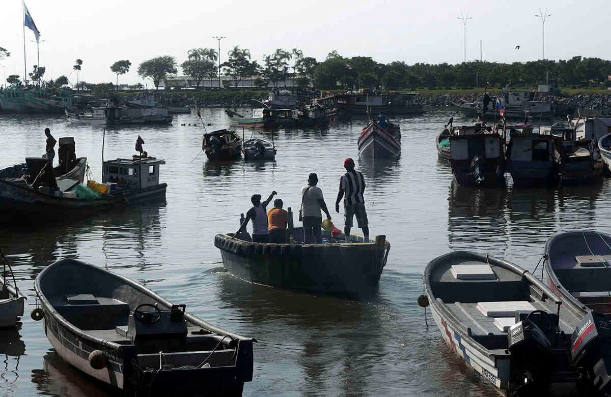  Los pescadores regresan de inspeccionar y reparar grandes embarcaciones, antes de salir del puerto del Mercado de Alimentos Marinos, en la Ciudad de Panamá, el 13 de mayo; el primer día que el gobierno levantó parcialmente el bloqueo establecido. Foto: Arnulfo Franco/ AP. 
