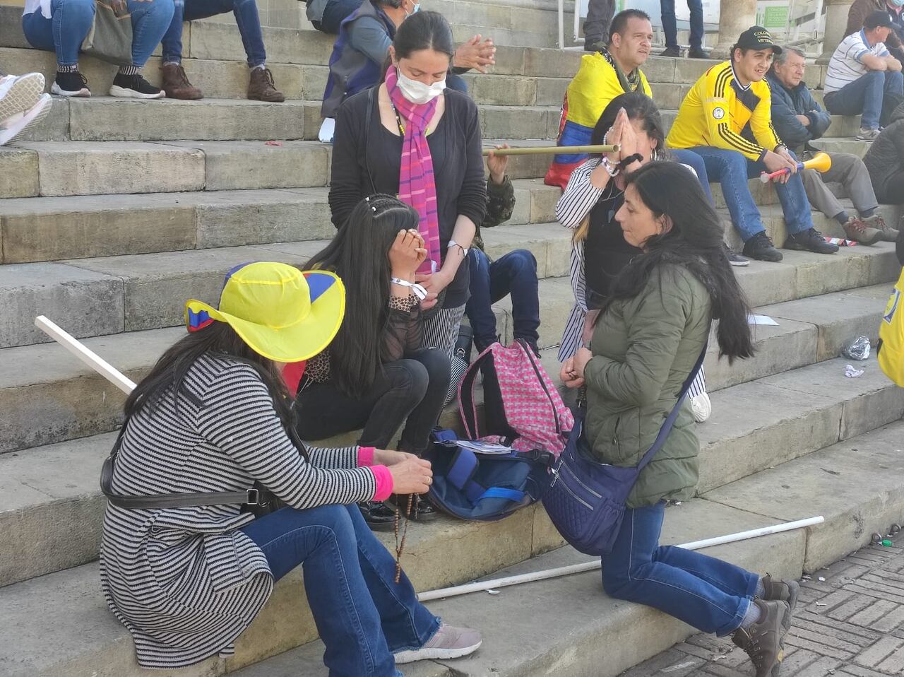 Algunas personas rezan con rosario en mano en la Plaza de Bolívar.