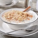 Un tazón de quinua caliente con azúcar morena, canela y leche para el desayuno.