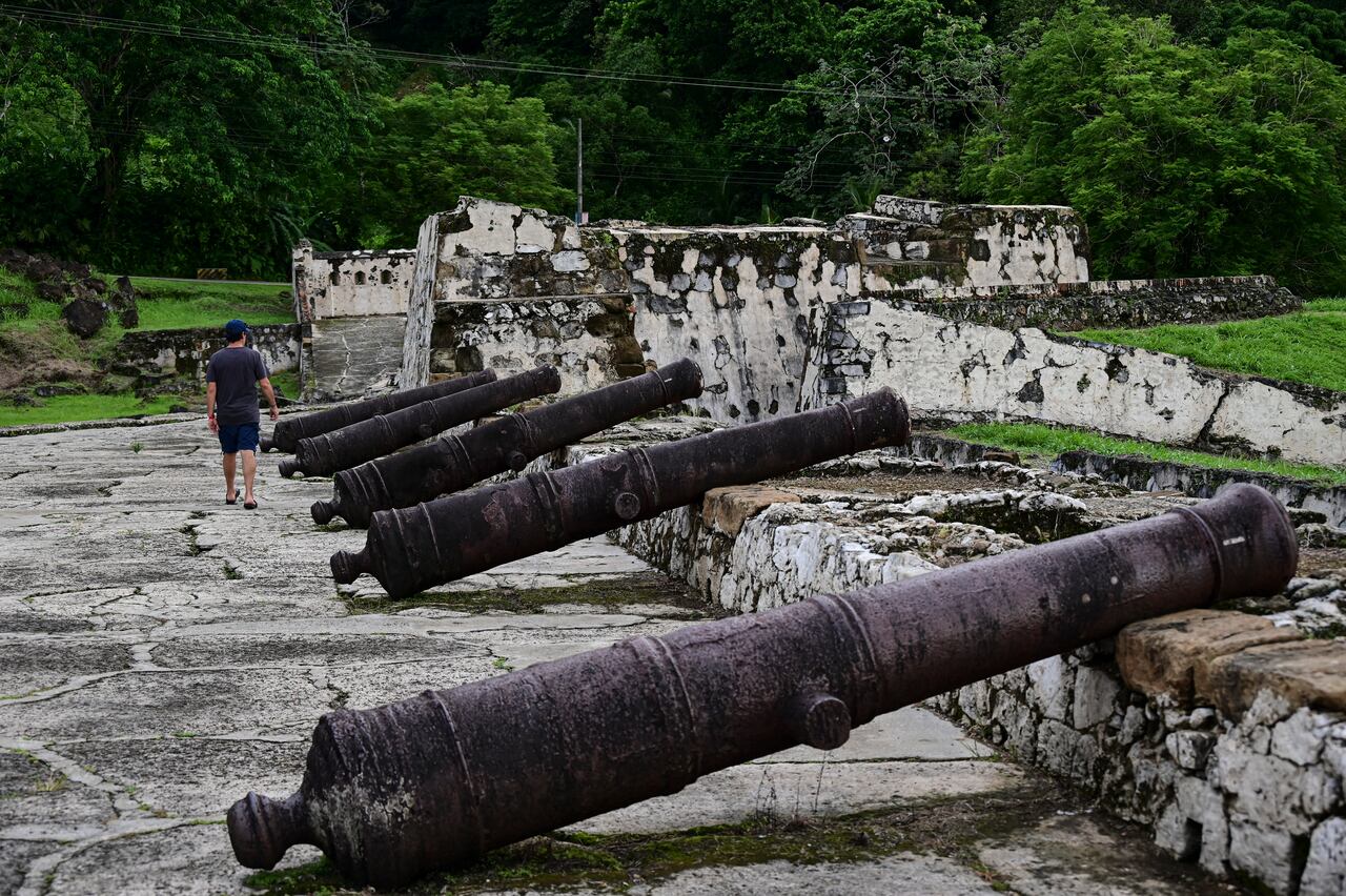 (ARCHIVOS) Un hombre camina junto a los cañones de la fortificación española de Portobelo en Portobelo, Panamá, 25 de mayo de 2024. El 12 de julio de 2025, la ruta colonial de Panamá, históricamente utilizada para transportar las riquezas de América en mula y barco durante siglos y que sirvió como precursora del canal interoceánico, fue designada Patrimonio de la Humanidad por la UNESCO. (Foto de MARTIN BERNETTI / AFP)