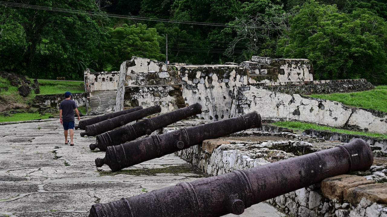(ARCHIVOS) Un hombre camina junto a los cañones de la fortificación española de Portobelo en Portobelo, Panamá, 25 de mayo de 2024. El 12 de julio de 2025, la ruta colonial de Panamá, históricamente utilizada para transportar las riquezas de América en mula y barco durante siglos y que sirvió como precursora del canal interoceánico, fue designada Patrimonio de la Humanidad por la UNESCO. (Foto de MARTIN BERNETTI / AFP)