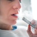 Primer plano de una mujer consumiendo cigarrillos electrónicos