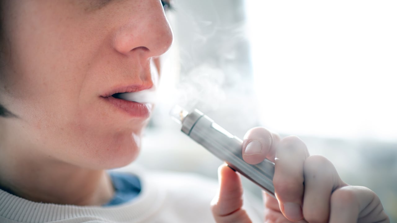 Primer plano de una mujer consumiendo cigarrillos electrónicos