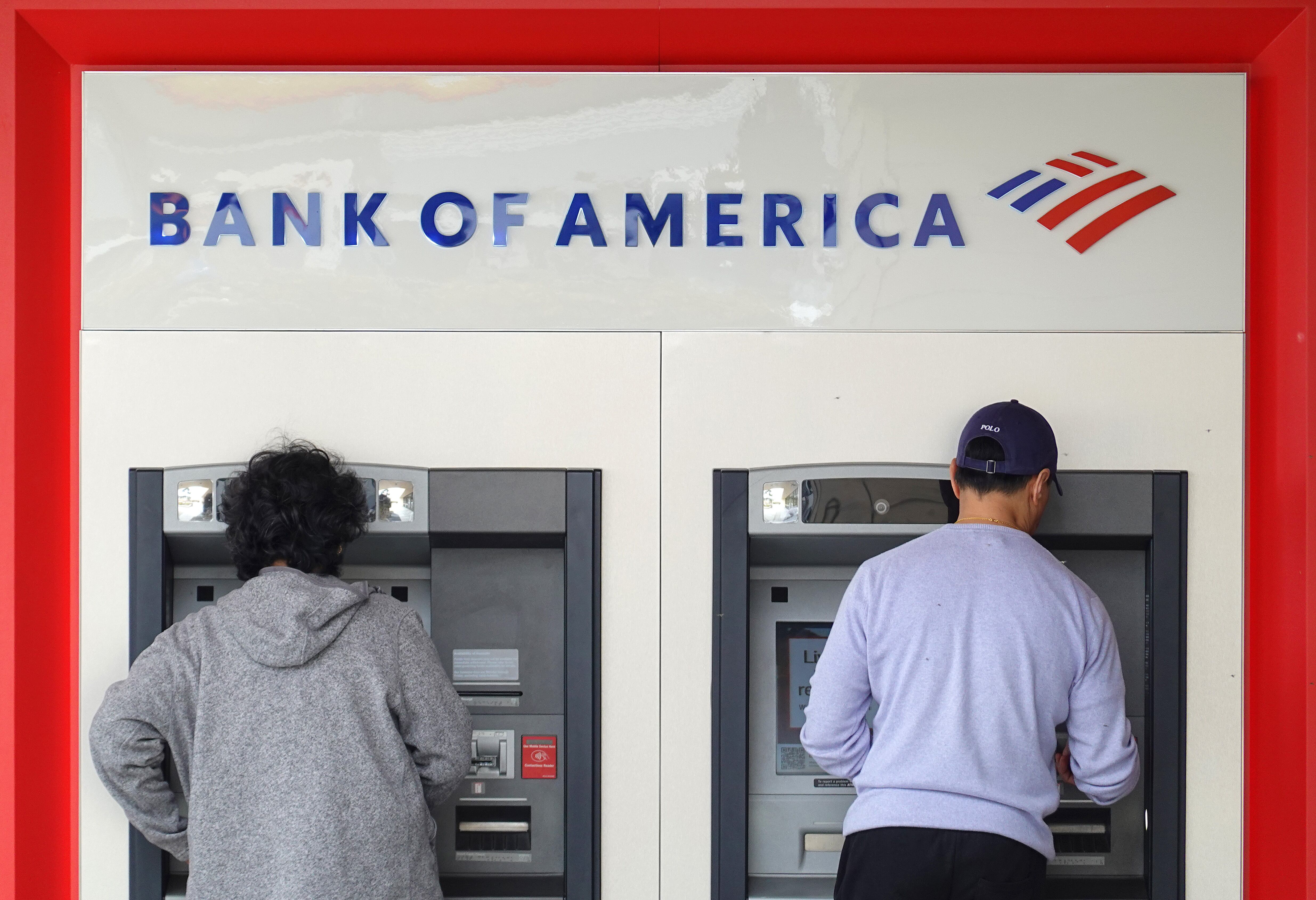 Los clientes utilizan un cajero automático en una oficina del Bank of America el 18 de julio de 2023 en Daly City, California.