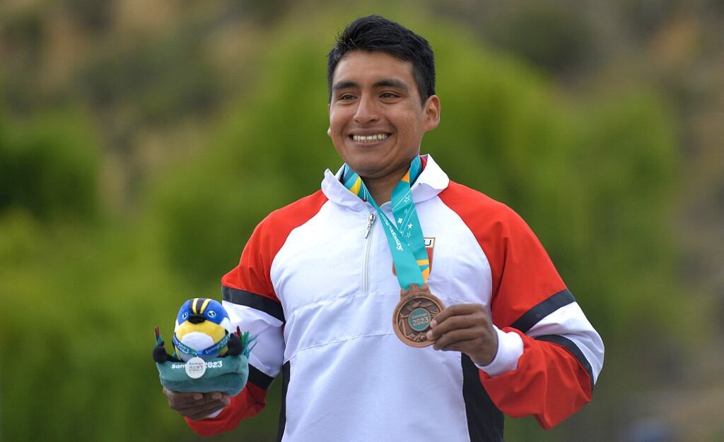 Eriberto Gutiérrez, de Perú, sube al podio con su medalla de bronce en la final masculina de kayak cross K1 durante los Juegos Panamericanos Santiago 2023, en el río Aconcagua en Los Andes, Región de Valparaíso, Chile, el 29 de octubre de 2023. (Foto de Guillermo SALGADO /AFP)