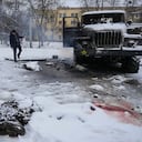 El cuerpo de un militar está cubierto de nieve mientras un hombre toma fotos de un vehículo lanzacohetes múltiple del ejército ruso destruido en las afueras de Kharkiv, Ucrania, el viernes 25 de febrero de 2022. Las tropas rusas atacaron la capital de Ucrania el viernes con disparos y explosiones que resuenan cada vez más cerca del barrio del gobierno, en una invasión de un país democrático que ha alimentado los temores de una guerra más amplia en Europa y ha desencadenado esfuerzos en todo el mundo para detener a Rusia. (Foto AP/Vadim Ghirda)