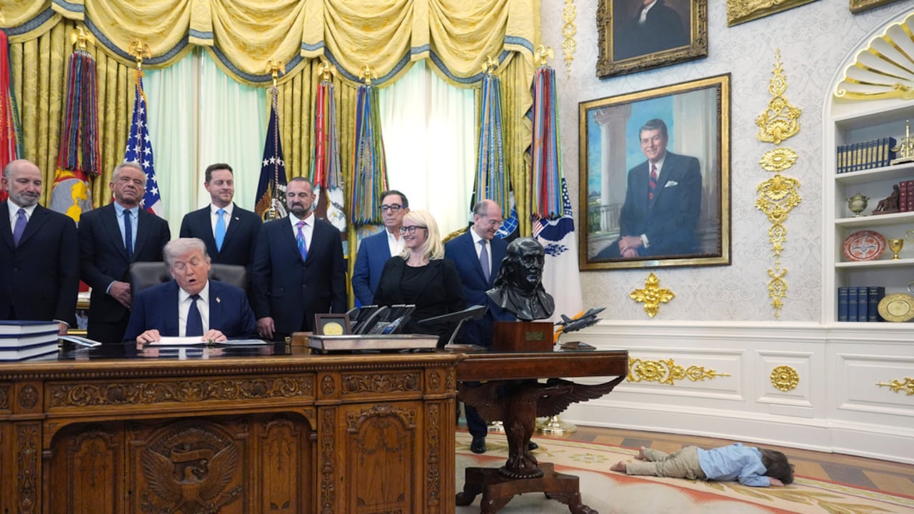Travis Smith, de dos años, yace en el suelo mientras el presidente Donald Trump habla durante un evento sobre la asequibilidad de la atención médica en el Despacho Oval de la Casa Blanca.