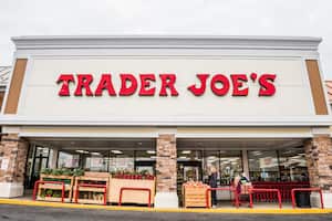 Fairfax, USA - November 25, 2016: Trader Joes grocery store facade with sign and items on display and people walking