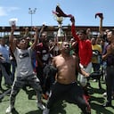 Venezuelan migrants celebrate with the trophy after winning the championship during the "Copa America Migrante 2023" football tournament in Ciudad Juarez, Chihuahua state, Mexico, on August 3, 2023. (Photo by Herika Martinez / AFP)