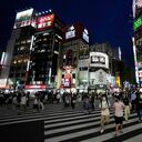 People walk along a pedestrian crossing Friday, July 30, 2021, in Tokyo, as Japanese Prime Minister Yoshihide Suga expanded a coronavirus state of emergency to four more areas in addition to Tokyo following record spikes in infections as the capital hosts the Olympics. (AP Photo/Eugene Hoshiko)