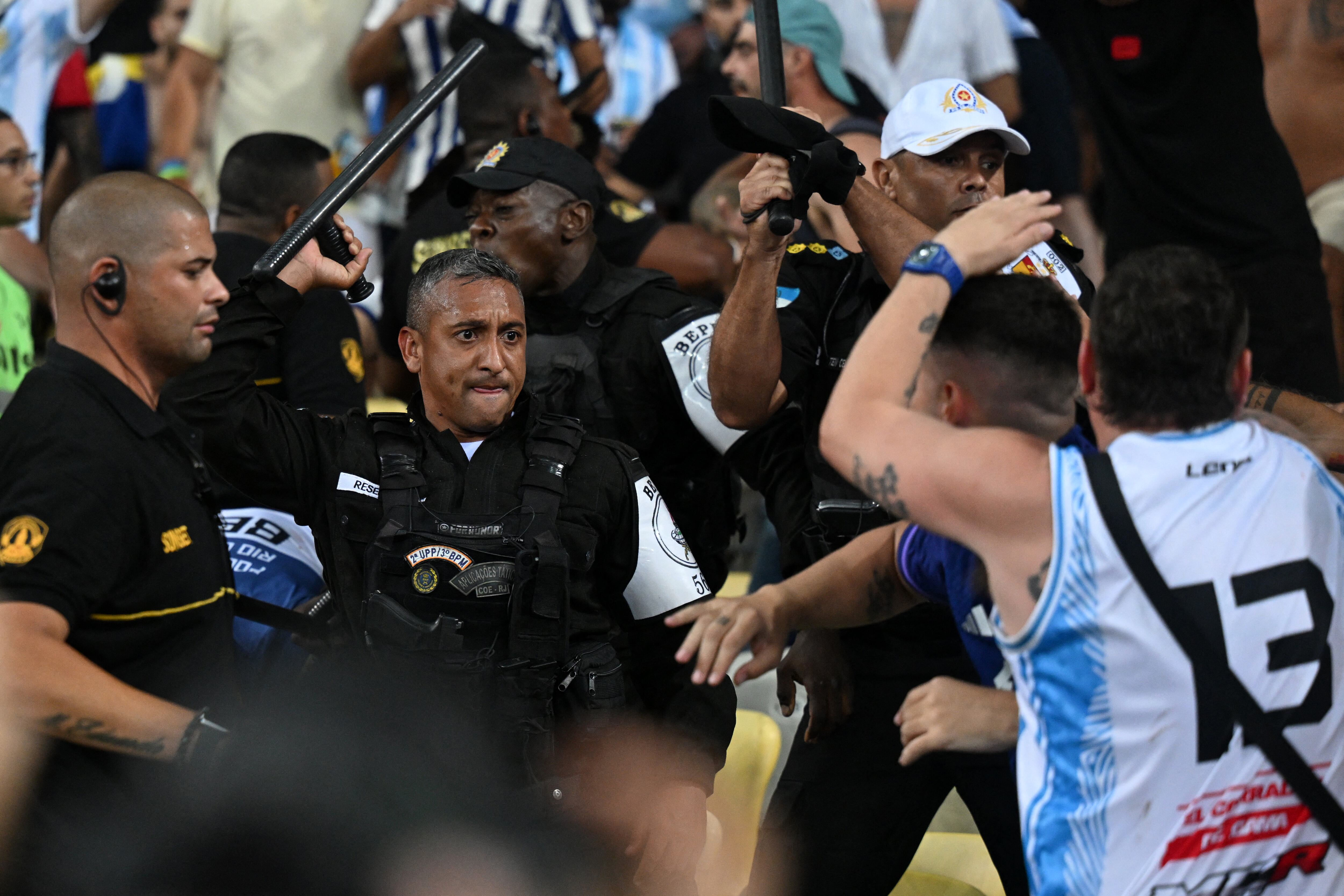 Fans of Argentina clash with Brazilian police before the start of the 2026 FIFA World Cup South American qualification football match between Brazil and Argentina at Maracana Stadium in Rio de Janeiro, Brazil, on November 21, 2023. (Photo by CARL DE SOUZA / AFP)
