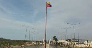 La descolorida bandera venezolana se levanta en medio de una extensa carretera solitaria, que está rodeada por los desiertos de La Guajira y las rancherías de los indígenas Wayú.