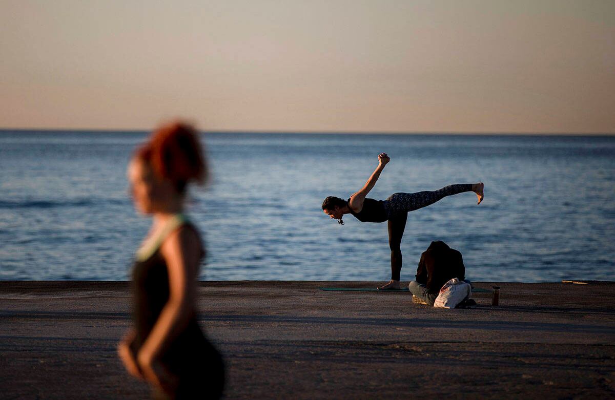 La gente hace ejercicio frente al mar en Barcelona, España, miércoles 20 de mayo de 2020. Barcelona permitió a las personas caminar en sus playas el miércoles, por primera vez desde el comienzo de la bloqueo hace más de dos meses por el virus. (Foto AP / Emilio Morenatti)