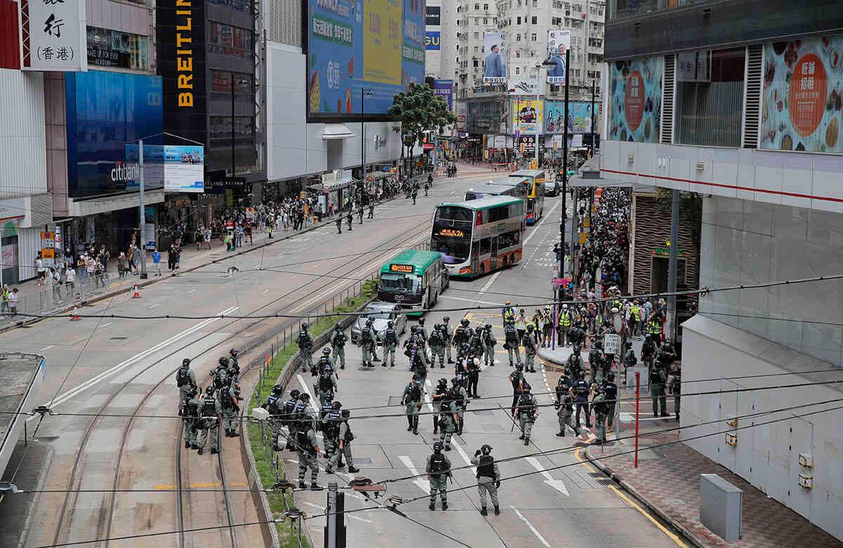 La policía estableció una línea de parámetros para controlar los movimientos de los manifestantes durante una protesta en Causeway Bay antes de la marcha anual de entrega en Hong Kong. Foto: Kin Cheung/AP