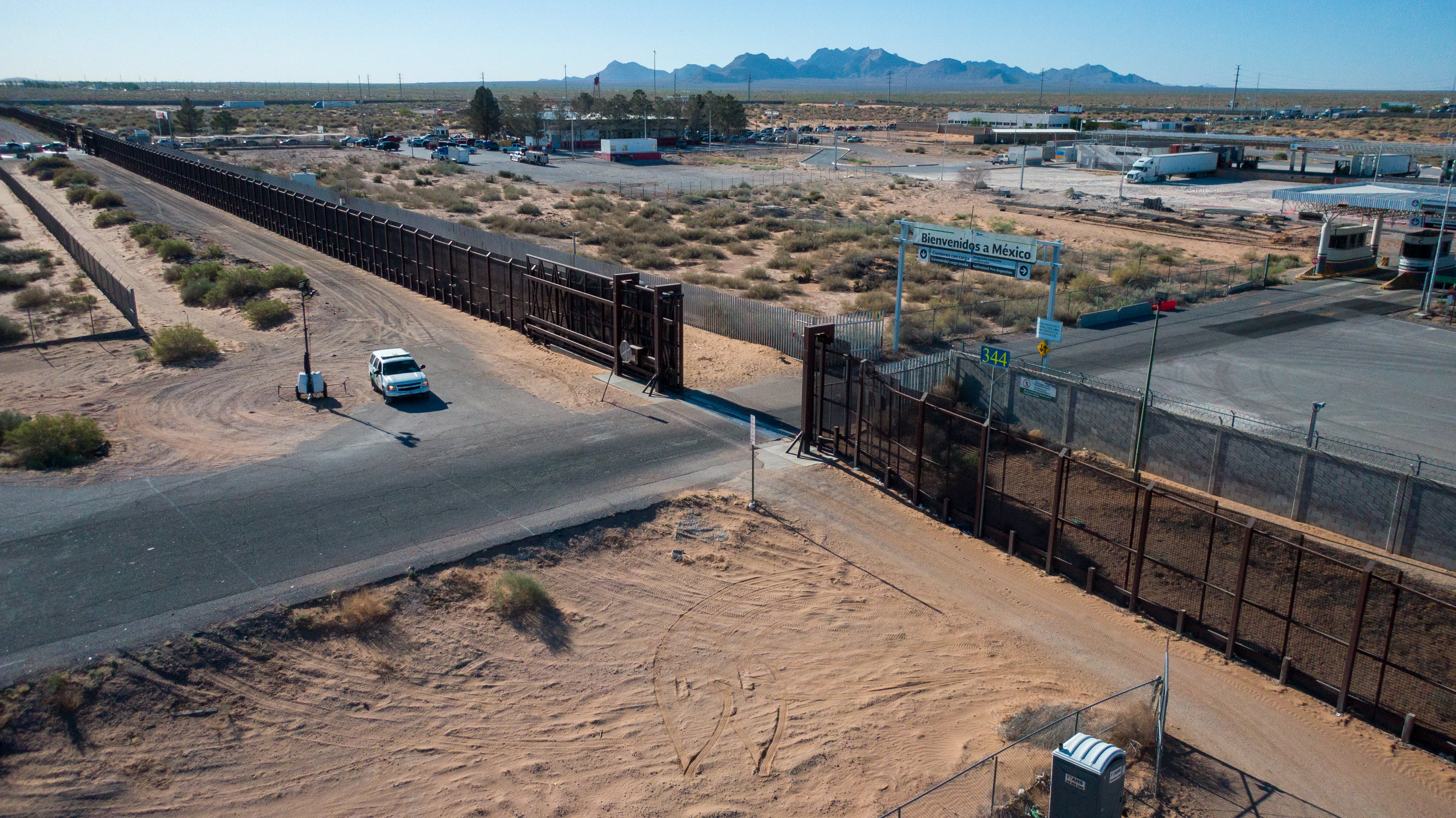 El muro fronterizo de los Estados Unidos en Nuevo México en el puerto de entrada de Santa Teresa de Aduanas y Protección Fronteriza de los Estados Unidos con un vehículo de la Patrulla Fronteriza vigilando