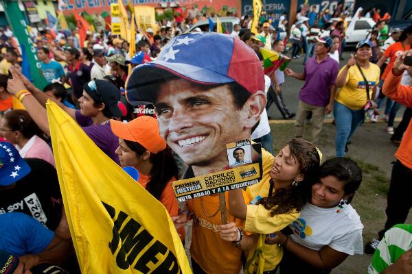 Seguidores del candidato presidencial opositor Capriles, exhiben pancartas de apoyo en un acto de campaña en la ciudad de San fernando.