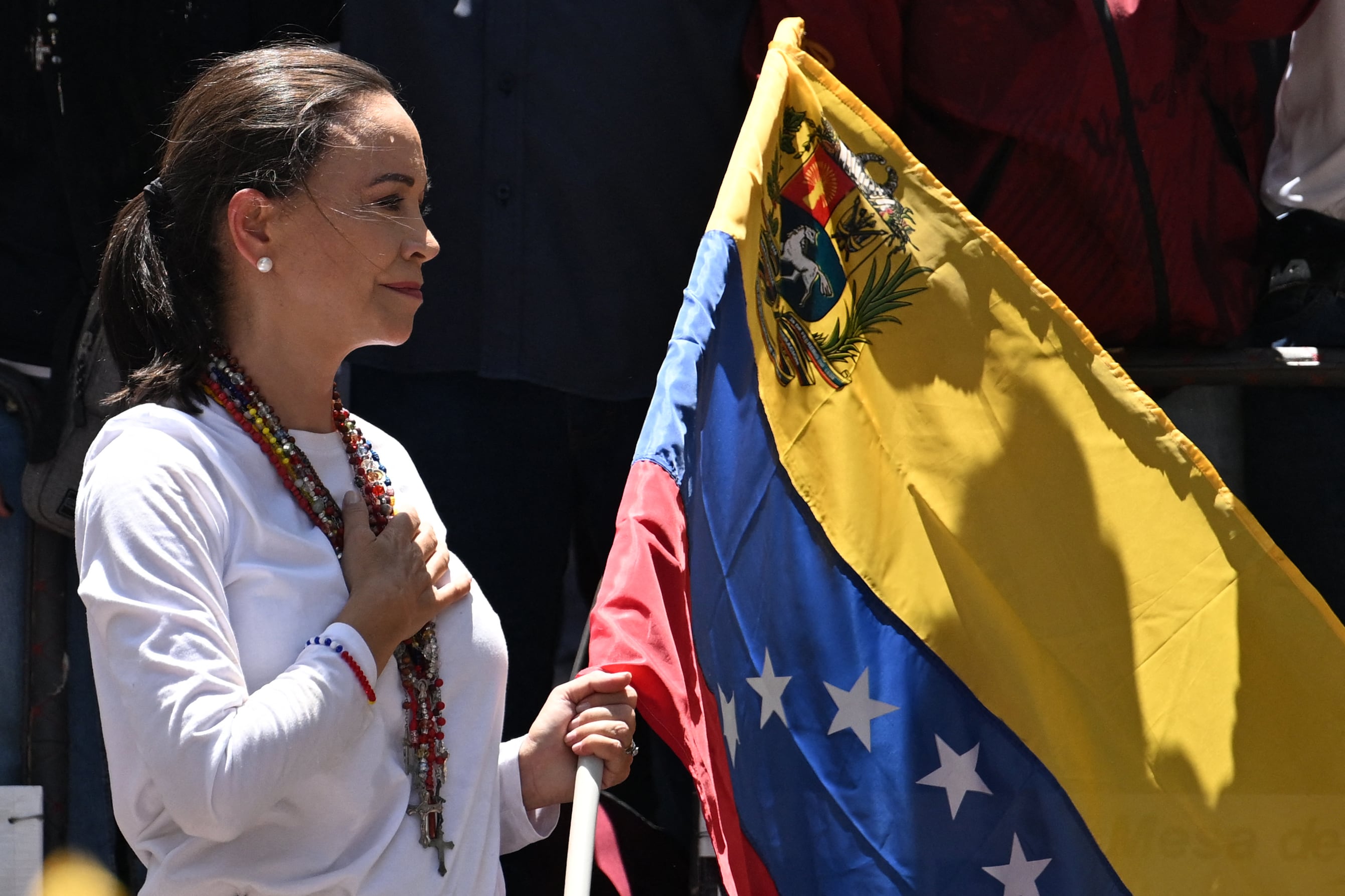 La líder de la oposición venezolana María Corina Machado sostiene una bandera nacional venezolana mientras hace gestos desde lo alto de un camión durante una manifestación para protestar por los resultados de las elecciones presidenciales, en Caracas el 3 de agosto de 2024. Venezuela se preparó para nuevas protestas después de que la disputada victoria electoral del presidente Nicolás Maduro fuera ratificado en la víspera, y un número creciente de naciones reconocieron a su rival de la oposición como el verdadero ganador. (Foto de Juan BARRETO/AFP)