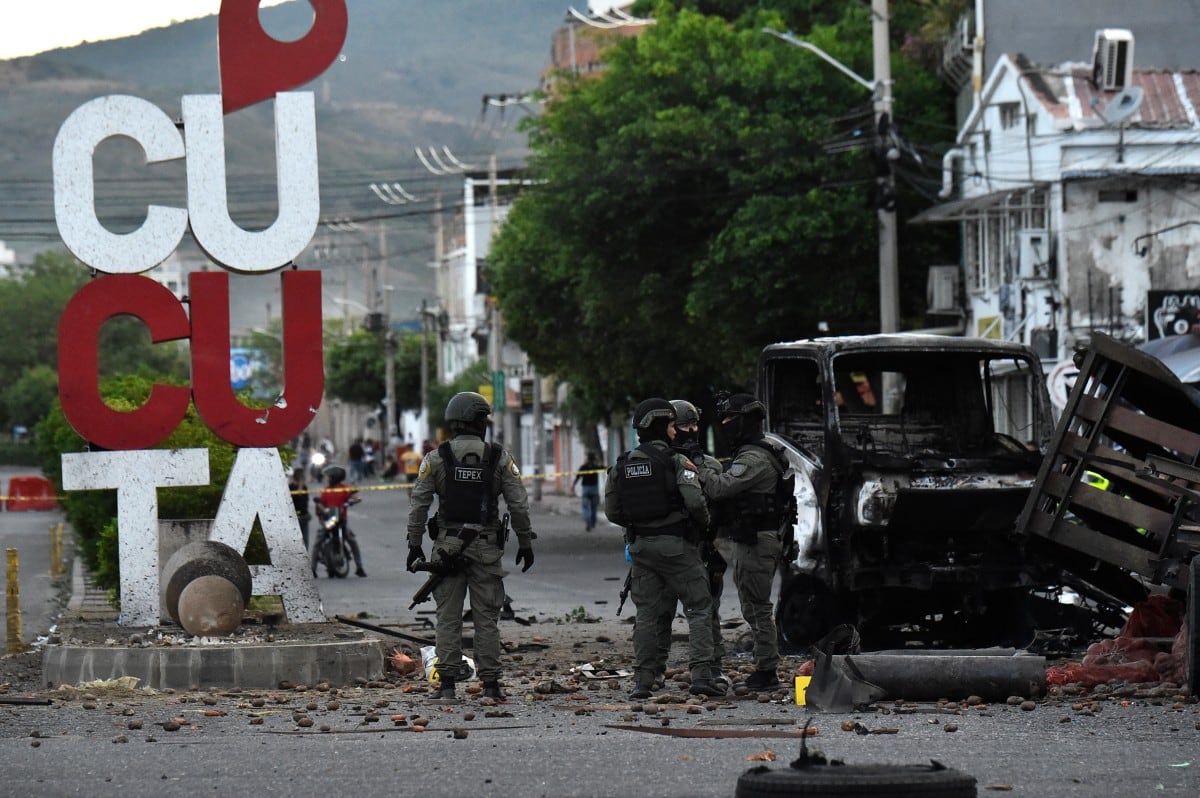 Agentes de Policía inspeccionan los restos de un camión tras la explosión de un carro bomba en Cúcuta.
