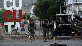 Agentes de Policía inspeccionan los restos de un camión tras la explosión de un carro bomba en Cúcuta.
